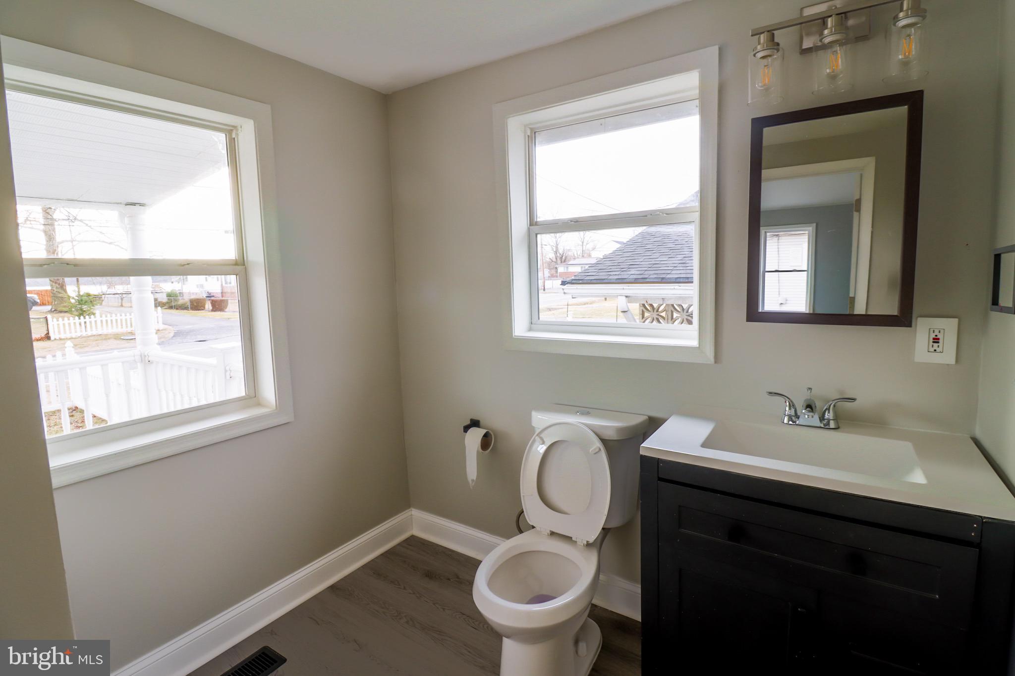 315 Riverside Drive Baltimore, MD 21221 - Photo 7 of 22 a bathroom with a toilet sink vanity and mirror