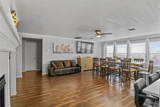 a living room with furniture wooden floor and a floor to ceiling window