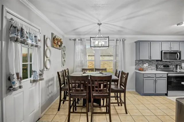 a view of a dining room with furniture a chandelier and kitchen view