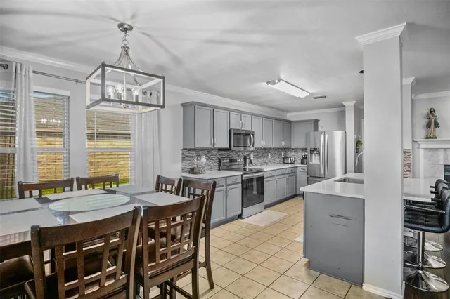 a kitchen with a table chairs stove and cabinets