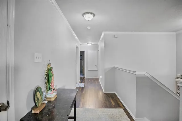 a view of a hallway with wooden floor and furniture