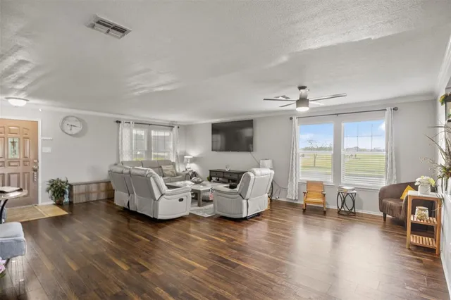 a living room with furniture floor to ceiling window and wooden floor