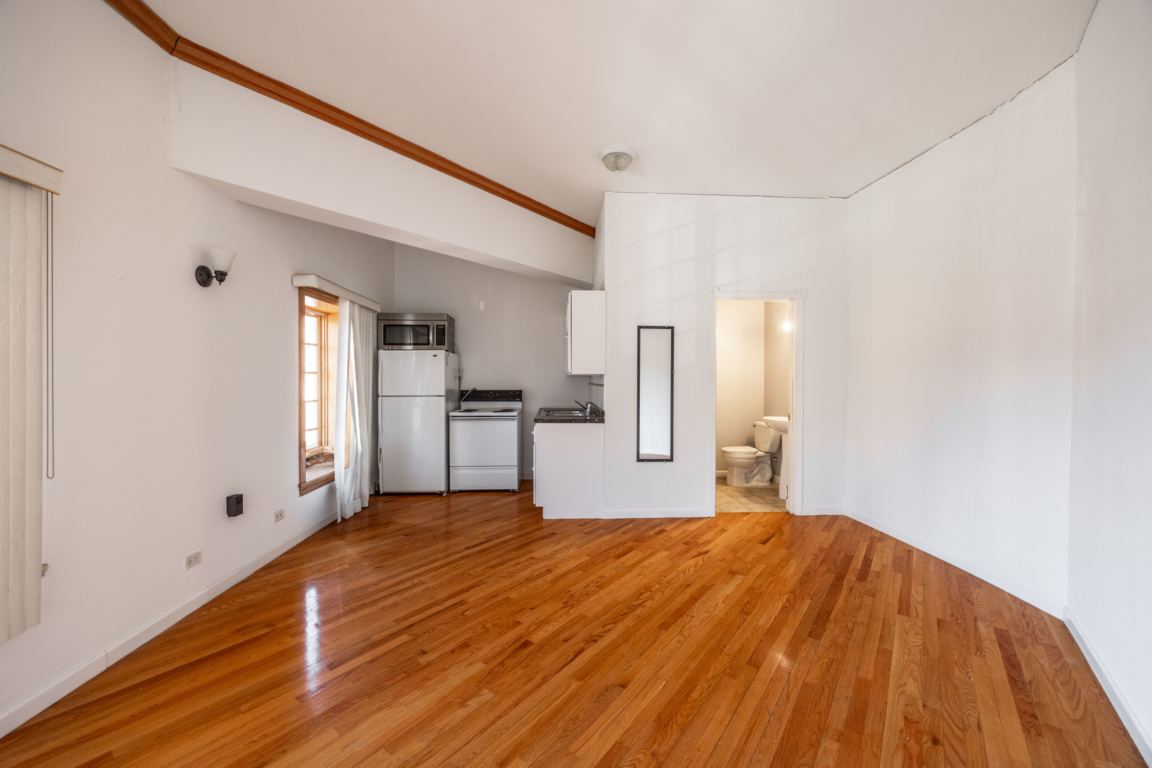 3107 North Harding Avenue, Unit 2W Chicago, IL 60618 - Photo 4 of 14 a view of a kitchen with wooden floor and a refrigerator