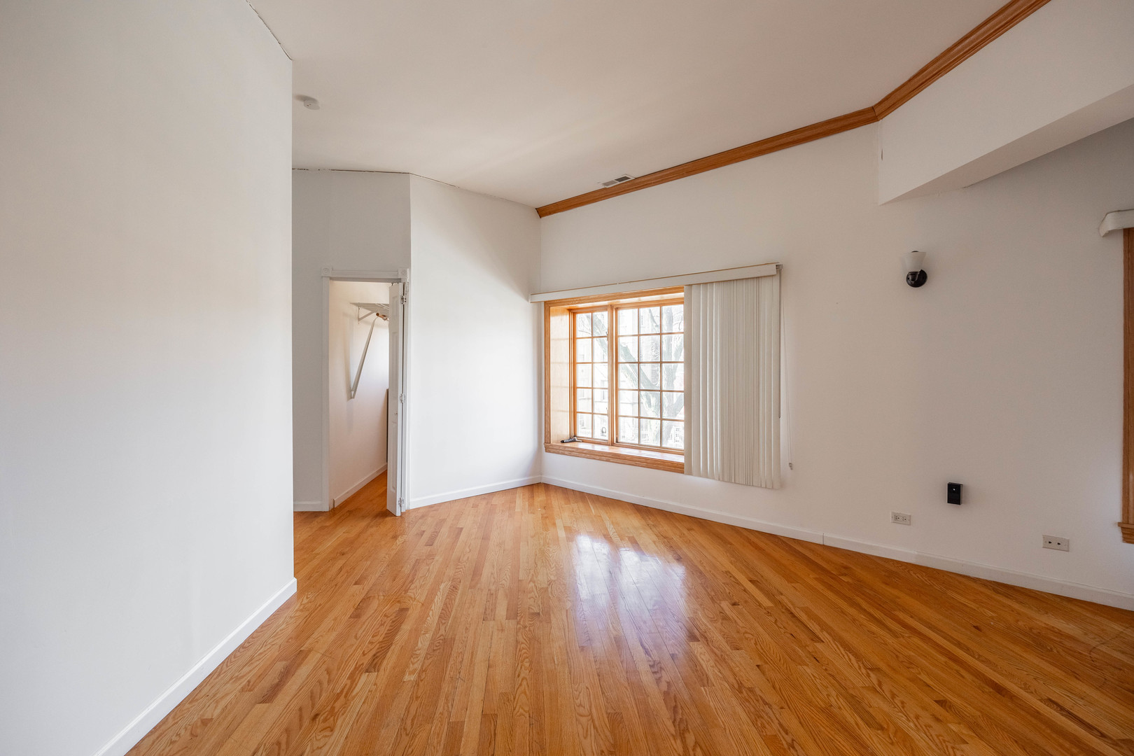 3107 North Harding Avenue, Unit 2W Chicago, IL 60618 - Photo 5 of 14 a view of an empty room with wooden floor and a window