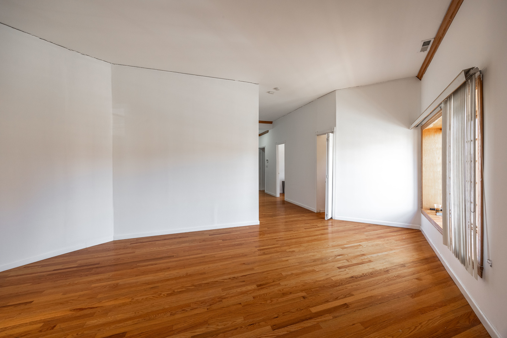 3107 North Harding Avenue, Unit 2W Chicago, IL 60618 - Photo 6 of 14 a view of an empty room with wooden floor and a window