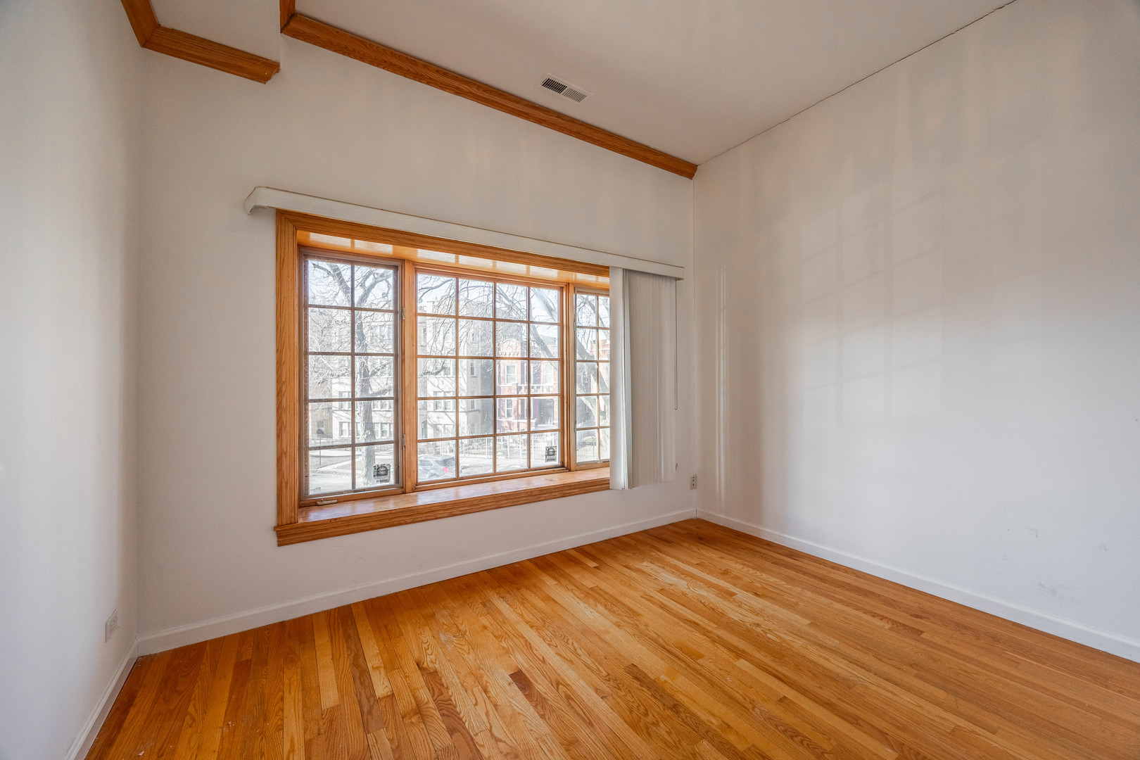 3107 North Harding Avenue, Unit 2W Chicago, IL 60618 - Photo 9 of 14 an empty room with wooden floor and windows