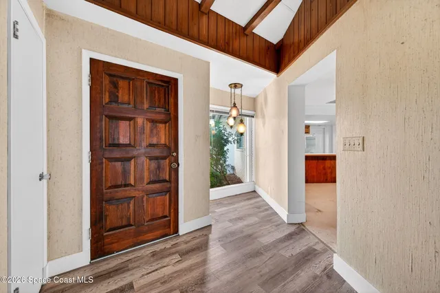 a view of a hallway with wooden floor and entryway