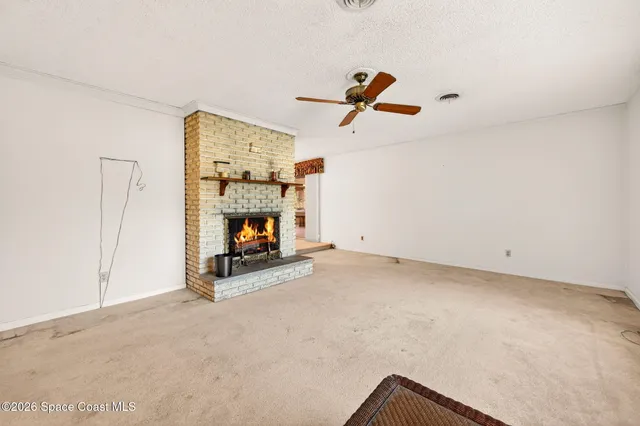a view of a livingroom with a fireplace and window