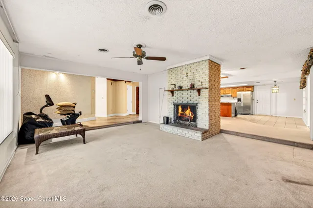 a view of a livingroom with a fireplace and a window