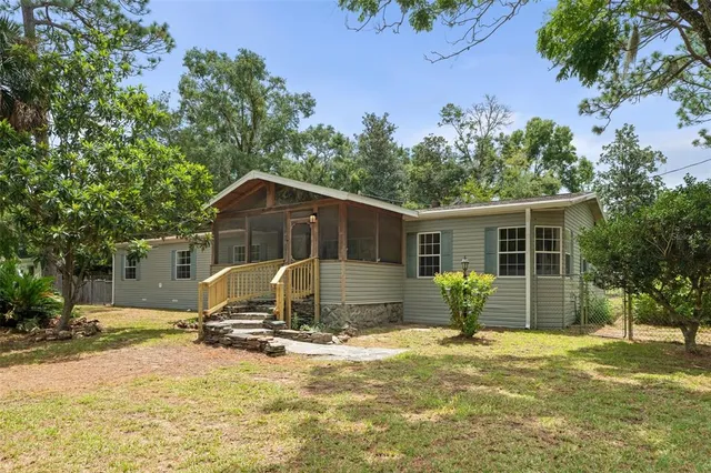 a view of a house with a yard and sitting area