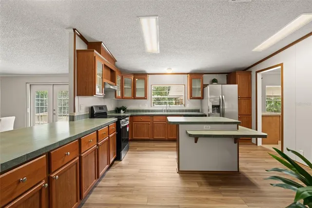 a kitchen with stainless steel appliances granite countertop a stove a sink dishwasher and a refrigerator