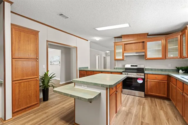 a kitchen with stainless steel appliances granite countertop sink stove top oven and cabinets