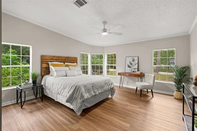 a bedroom with a bed a table and a large window