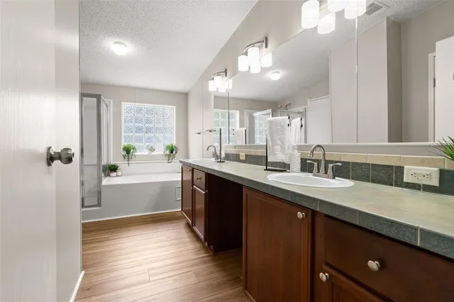a large kitchen with a sink and dishwasher with wooden floor