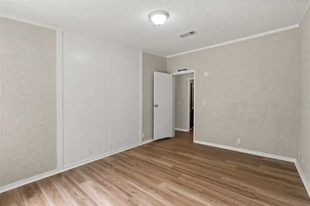 a view of an empty room with wooden floor