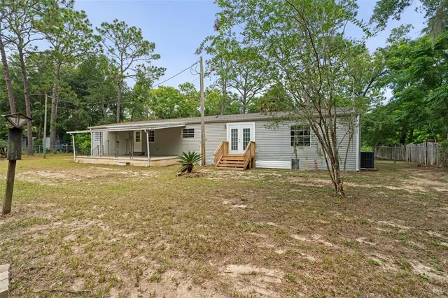 a view of a house with backyard and trees