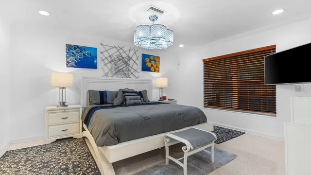 a bedroom with a bed and a chandelier