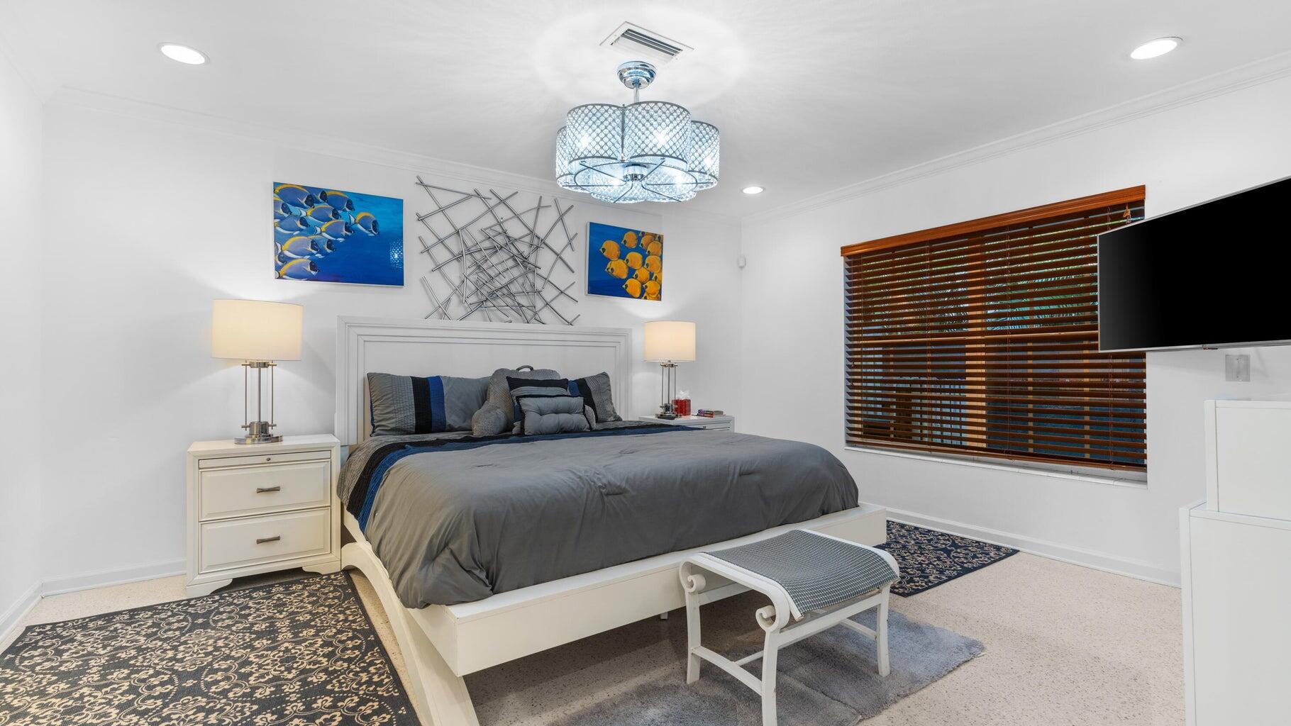 410 Venetian Drive Delray Beach, FL 33483 - Photo 12 of 28 a bedroom with a bed and a chandelier