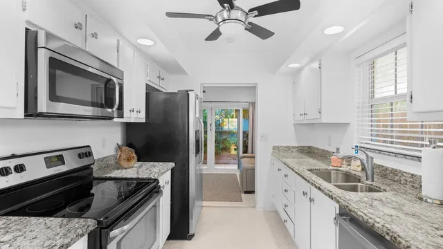 a kitchen with stainless steel appliances granite countertop a stove sink microwave and refrigerator