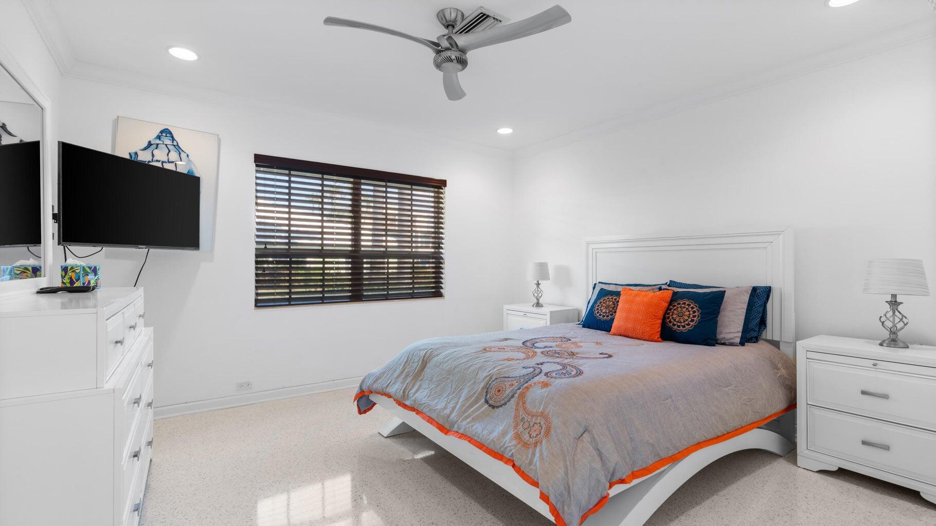 410 Venetian Drive Delray Beach, FL 33483 - Photo 18 of 28 a bedroom with a bed and a flat screen tv