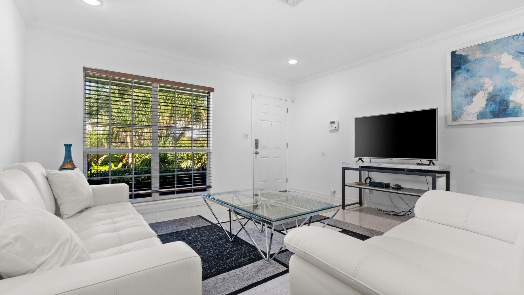 410 Venetian Drive Delray Beach, FL 33483 - Photo 22 of 28 a living room with furniture and a flat screen tv