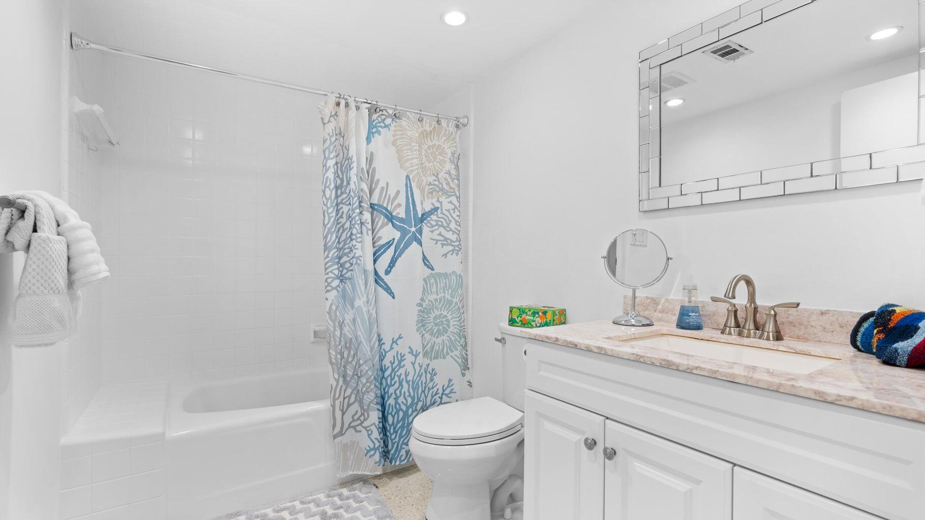 410 Venetian Drive Delray Beach, FL 33483 - Photo 9 of 28 a bathroom with a granite countertop sink a toilet and a bathtub
