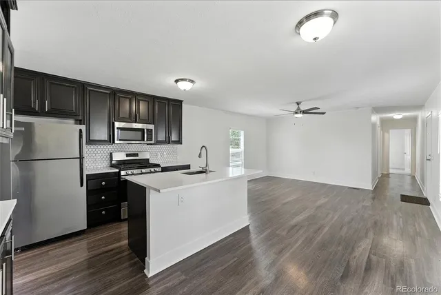 a kitchen with stainless steel appliances a stove microwave and refrigerator