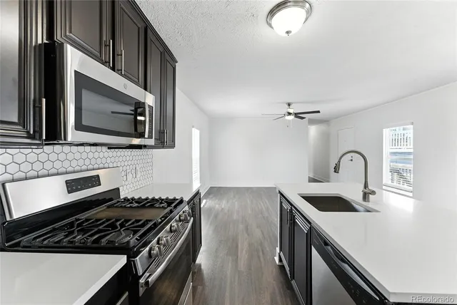 a kitchen with stainless steel appliances a refrigerator a stove a sink and a refrigerator