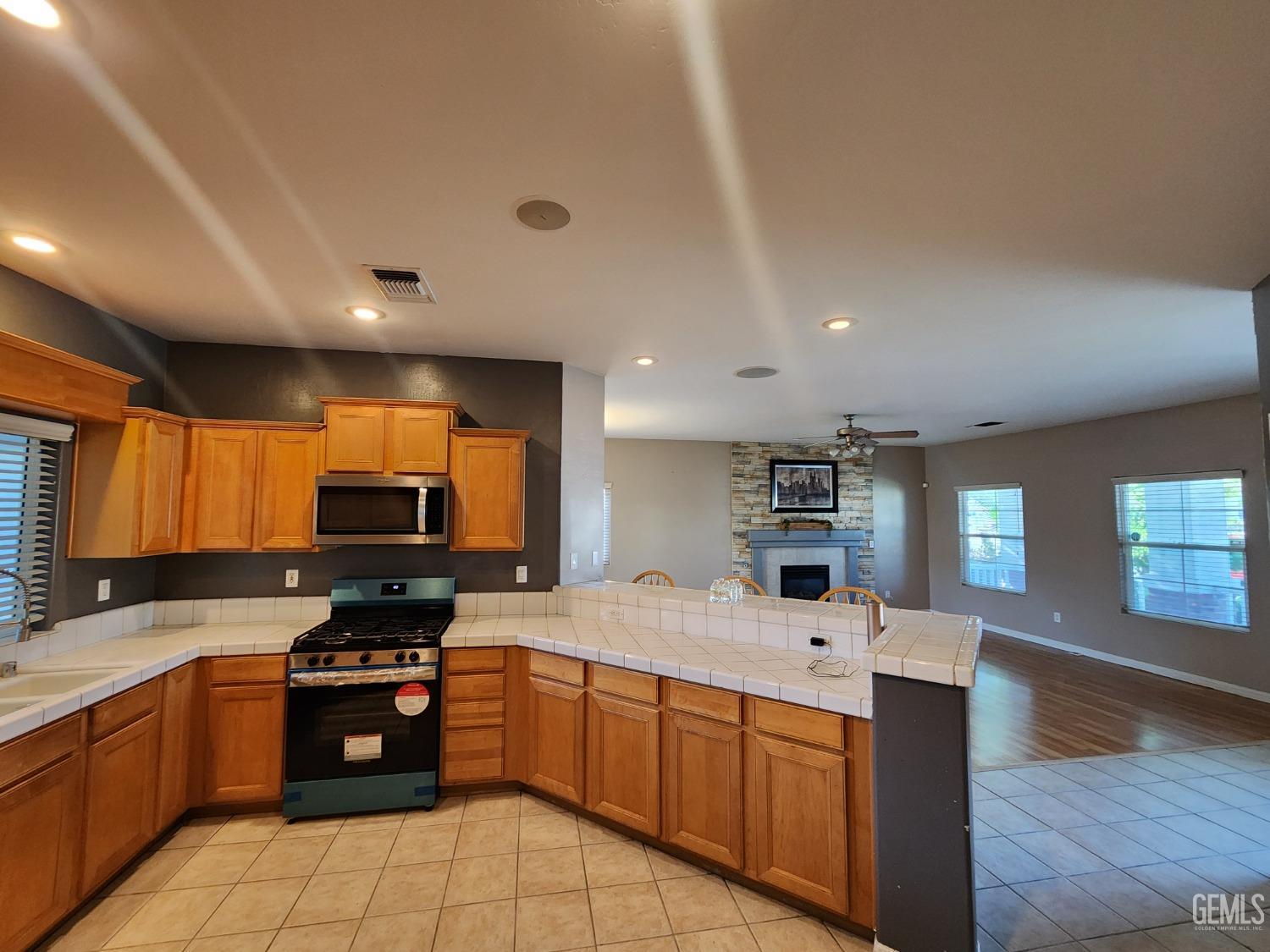 Undisclosed Address Bakersfield, CA 93313 - Photo 12 of 19 a kitchen with stainless steel appliances a stove sink microwave and cabinets