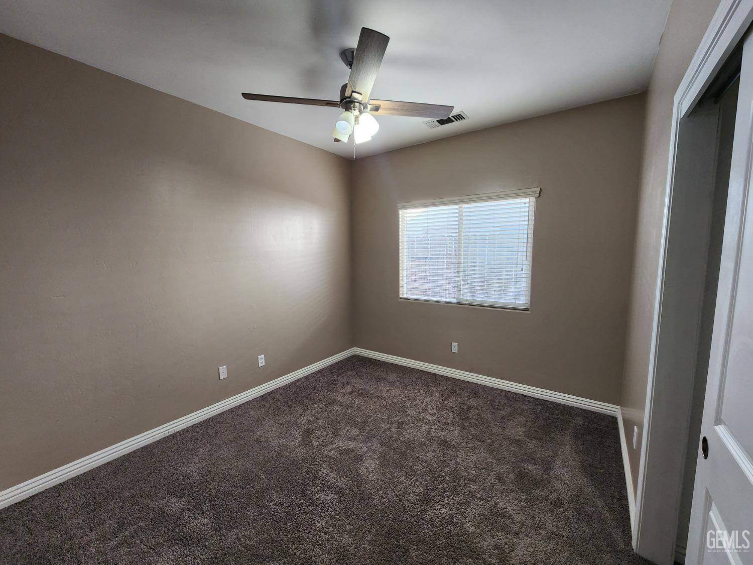 Undisclosed Address Bakersfield, CA 93313 - Photo 13 of 19 an empty room with chandelier fan and windows