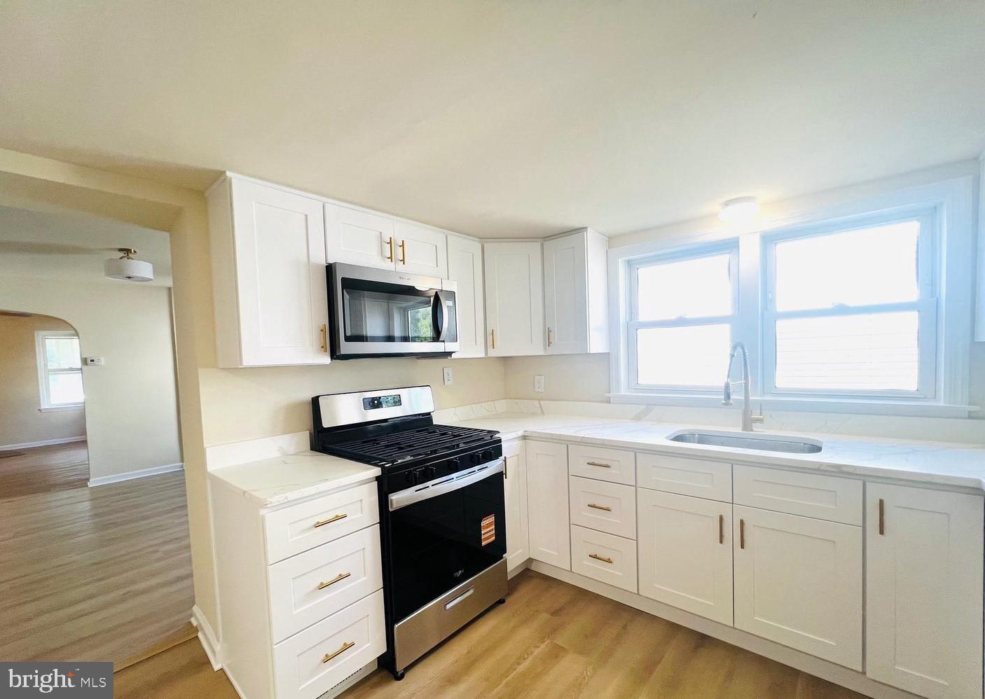 617 3rd Street Beverly, NJ 08010 - Photo 4 of 16 a kitchen with granite countertop a stove a sink and a microwave
