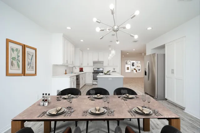 a open dining room with stainless steel appliances kitchen island a table and chairs