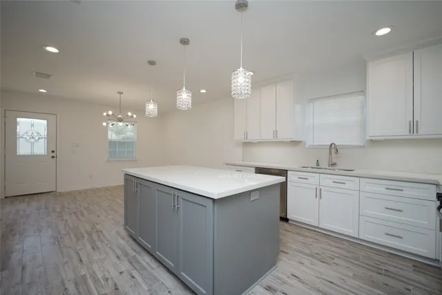 a kitchen with a sink cabinets and wooden floor