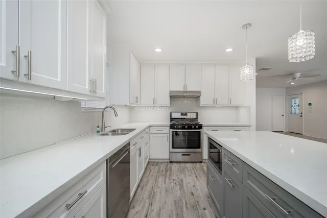 a kitchen with a sink a stove and cabinets