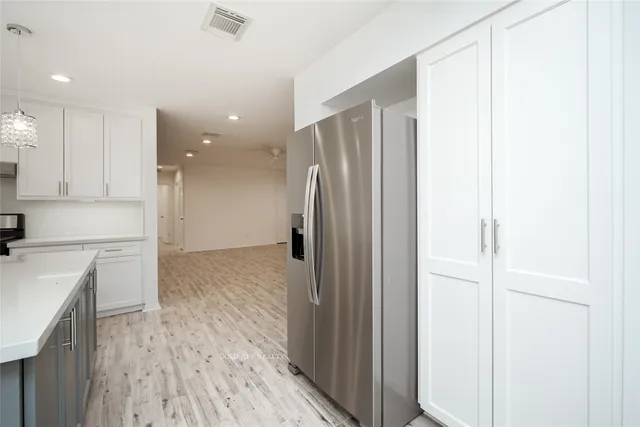 a view of a kitchen with a refrigerator and a stove top oven