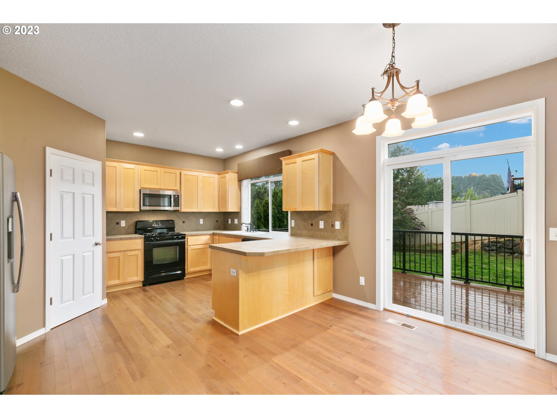 3314 South 2nd Way Ridgefield, WA 98642 - Photo 8 of 27 a open kitchen with stainless steel appliances granite countertop a refrigerator a stove a sink dishwasher a oven with white cabinets and wooden floor