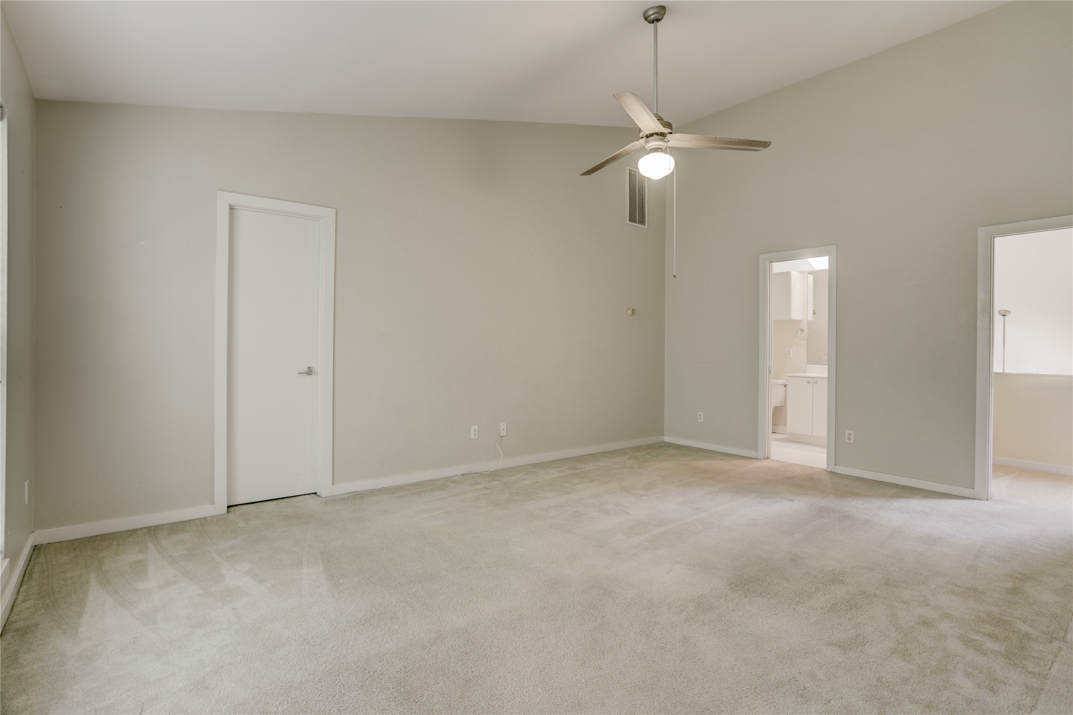 910 Ruthven Street Houston, TX 77019 - Photo 19 of 35 Another view of the primary bedroom with carpeting and lighted ceiling fan. On the right, there’s access to a balcony overlooking living room and to the left is the primary bath.