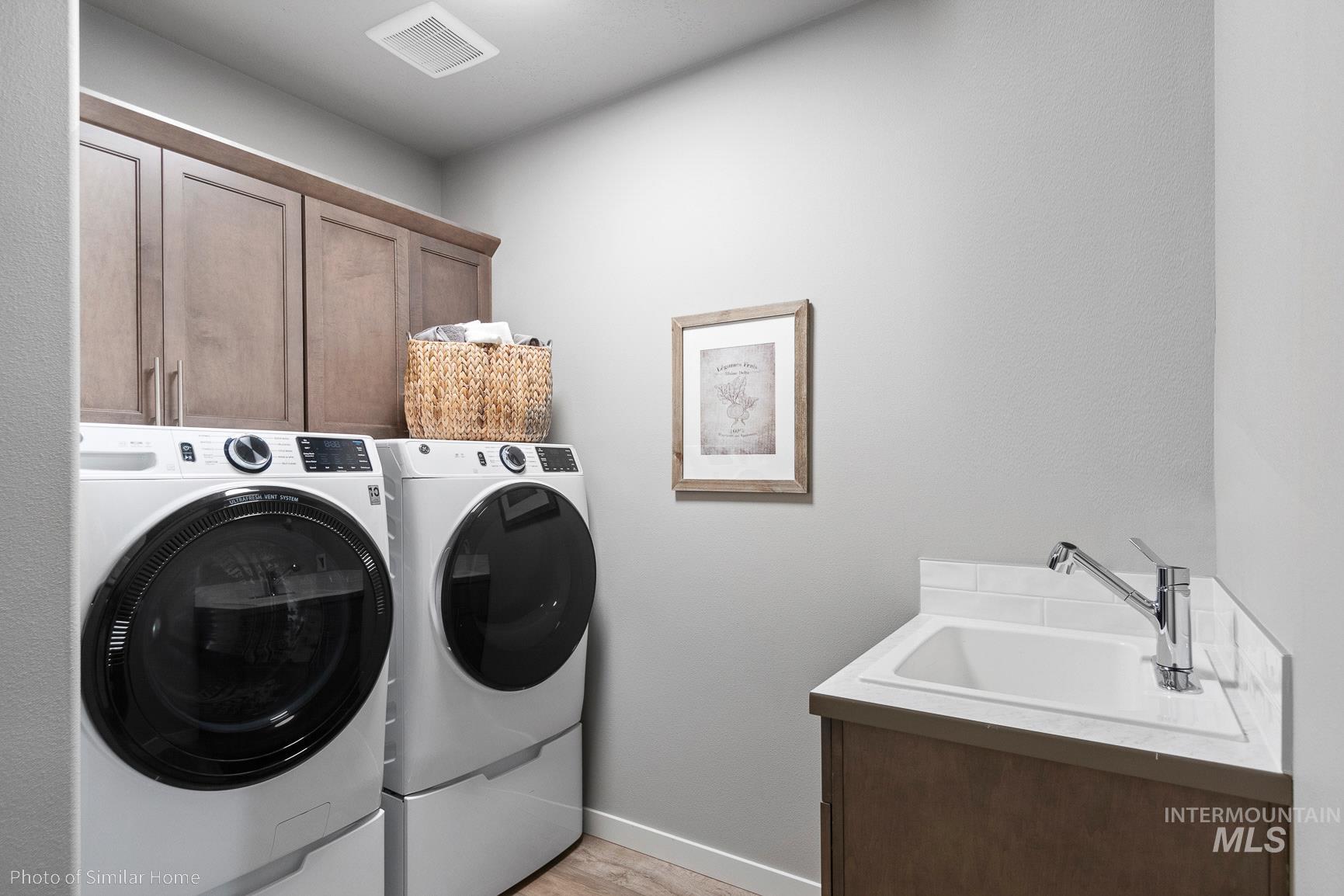 382 West Gleason Court Meridian, ID 83646 - Photo 15 of 21 Laundry area with cabinet space, washing machine and dryer, and light wood finished floors