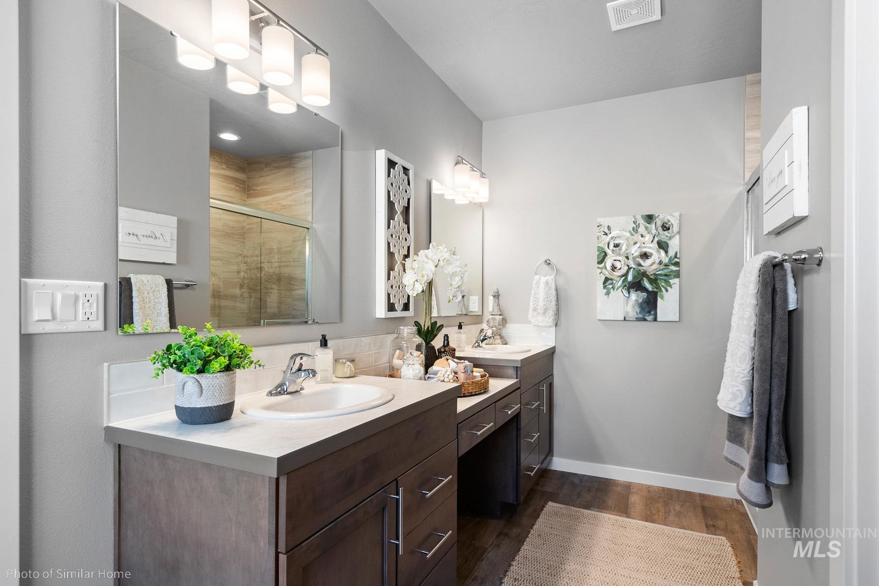 382 West Gleason Court Meridian, ID 83646 - Photo 18 of 21 Bathroom with double vanity, a stall shower, and dark wood-style floors