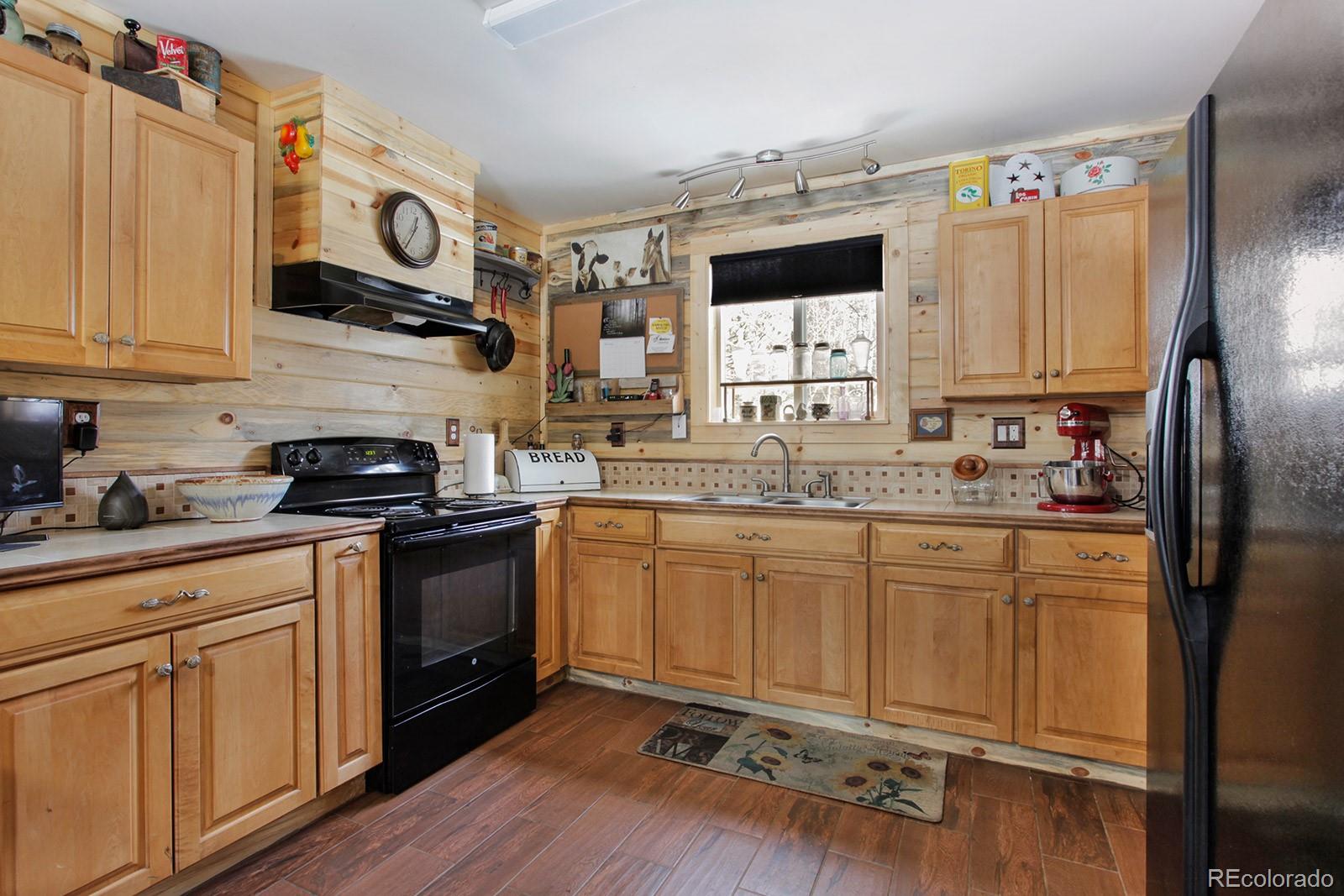 274 Buffum Street Bailey, CO 80421 - Photo 5 of 13 a kitchen with stainless steel appliances granite countertop a stove a sink dishwasher and a refrigerator with wooden floor