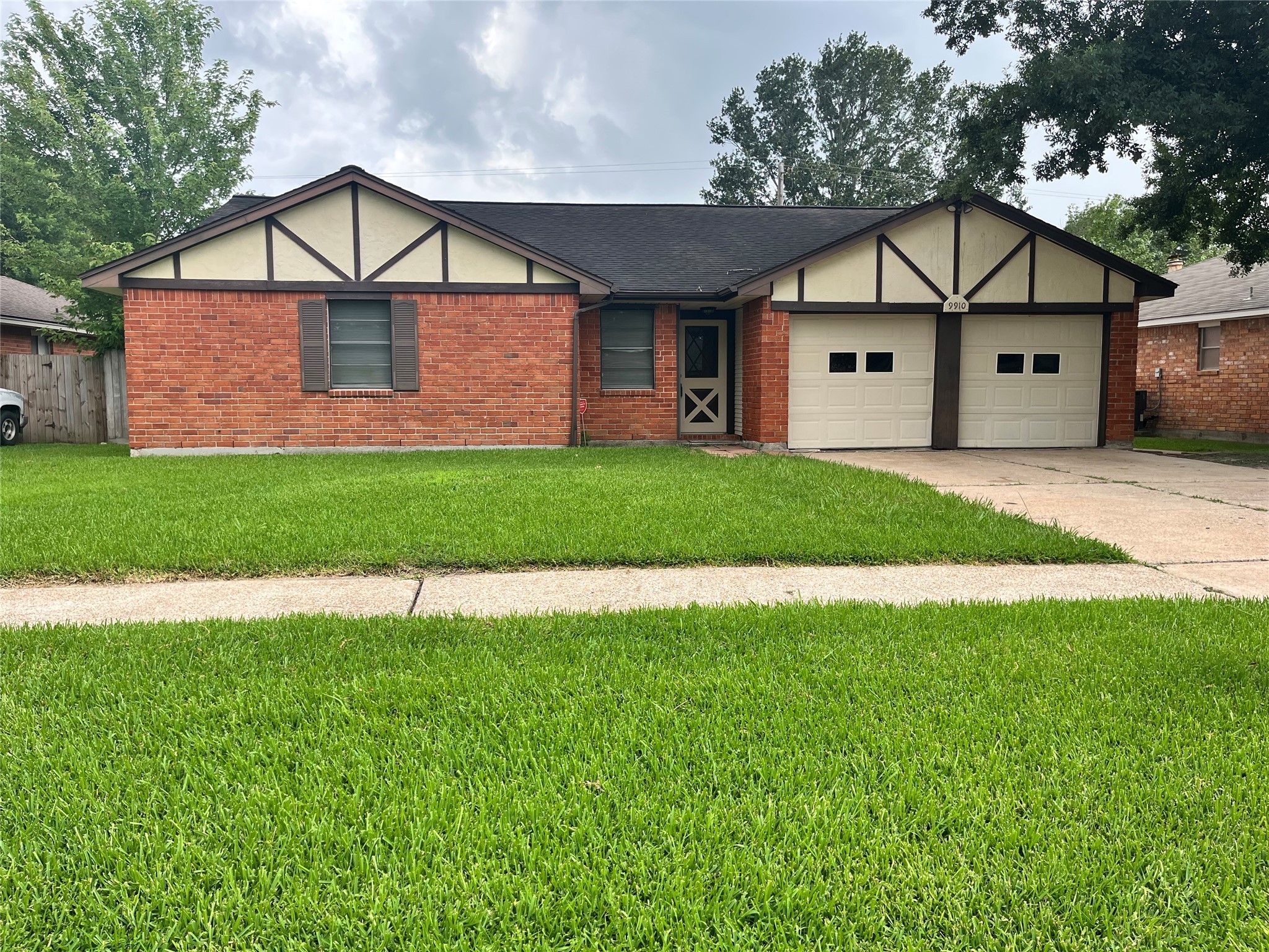 a view of a house with a yard and large tree