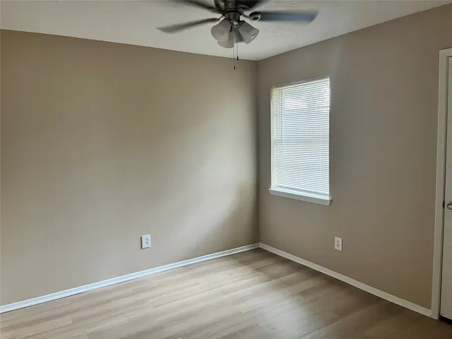 an empty room with a window and a fan