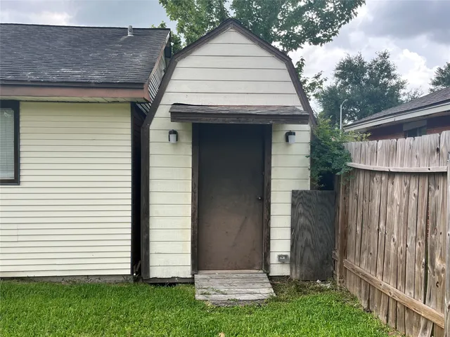 a view of a white house with a small garden