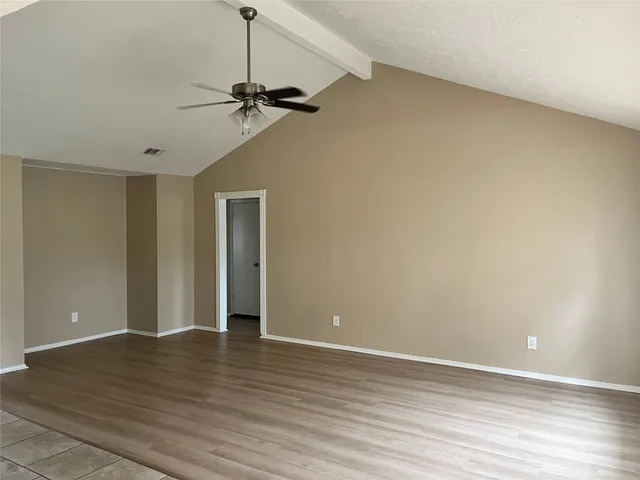 a view of a livingroom with a ceiling fan window and wooden floor