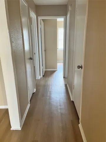 a view of a hallway with wooden floor