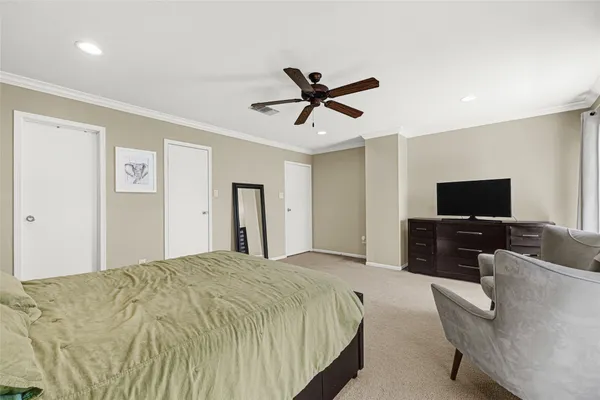 a bedroom with a bed a couch and a flat screen tv