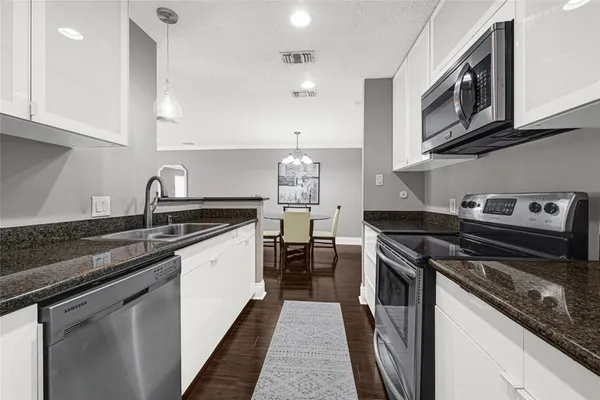 a kitchen with stainless steel appliances granite countertop a sink stove and cabinets