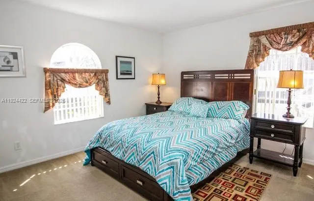 a bedroom with a bed and a lamp on dresser