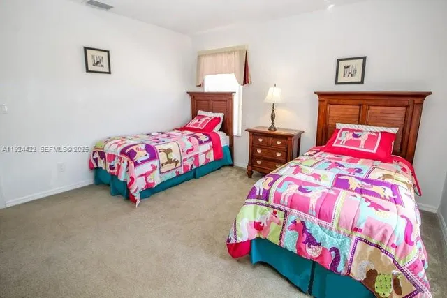 a bedroom with two bed and a lamp