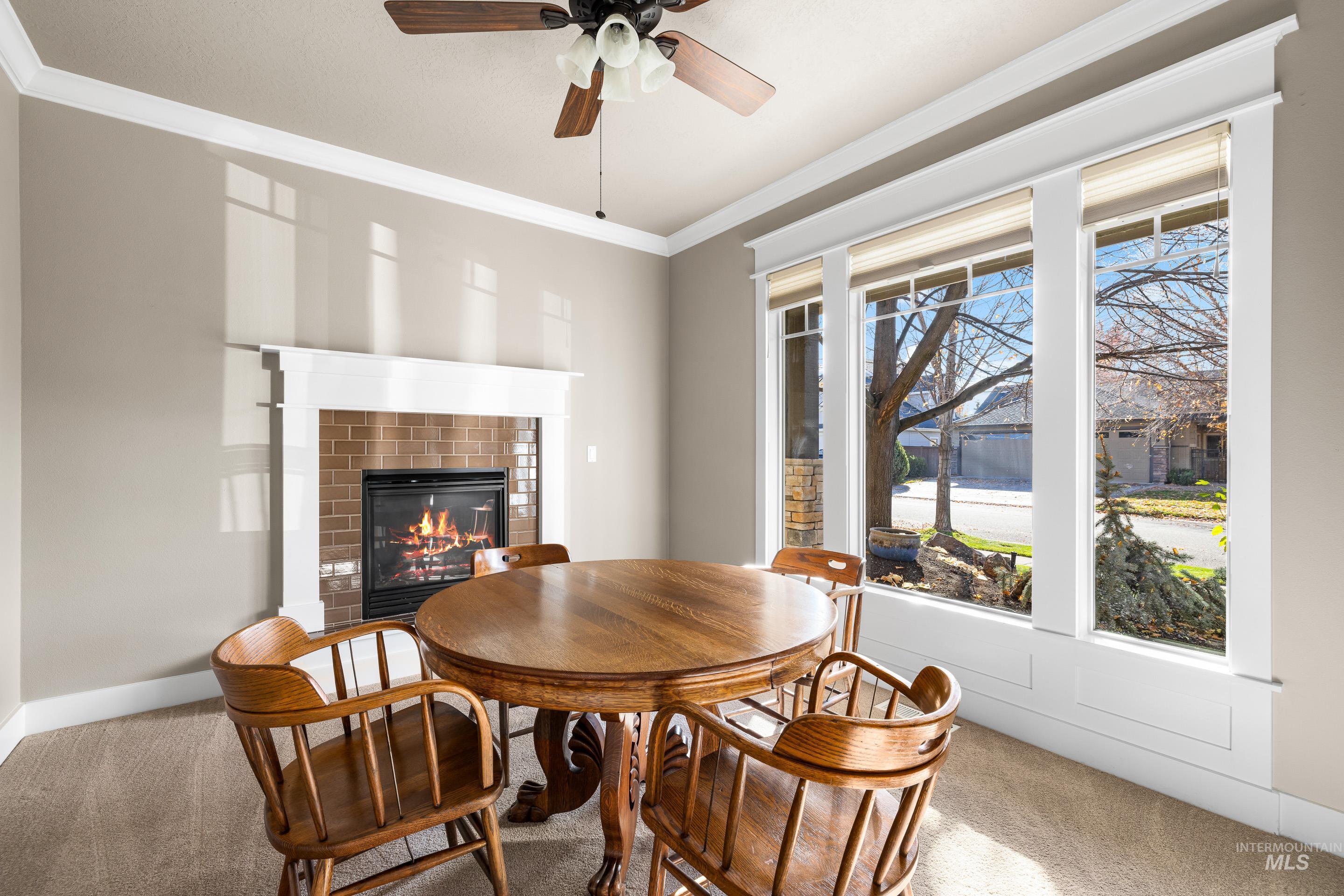 836 West Colbert Street Meridian, ID 83646 - Photo 7 of 45 Dining area featuring carpet, ornamental molding, a glass covered fireplace, and a ceiling fan